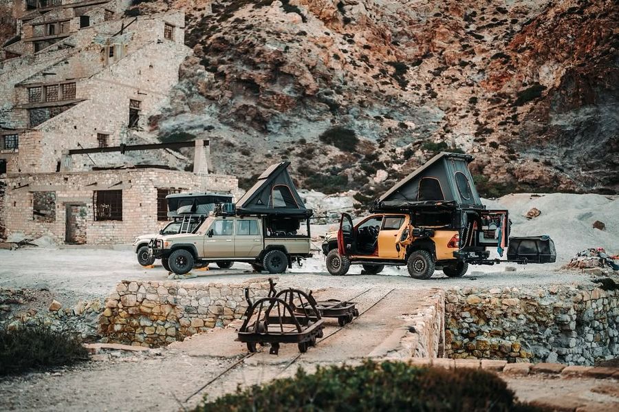 Two overland vehicles with Alu-Cab tents at an old mine